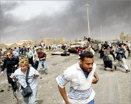 Reporters flee from a wrecked tank as US jets fly overhead   