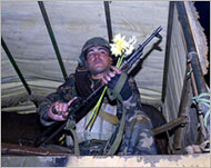 A Syrian soldier in the back of an army truck returns from Lebanon