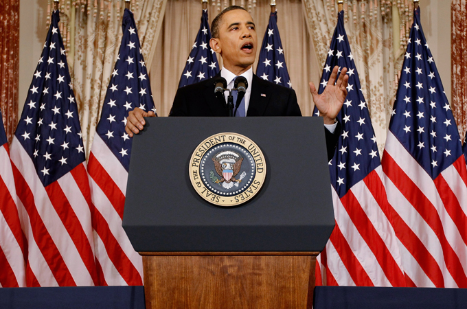 Barack Obama in front of lots of US flags