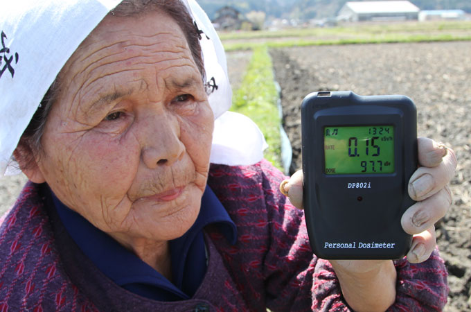 Japanese farmer with geiger counter near fukushima