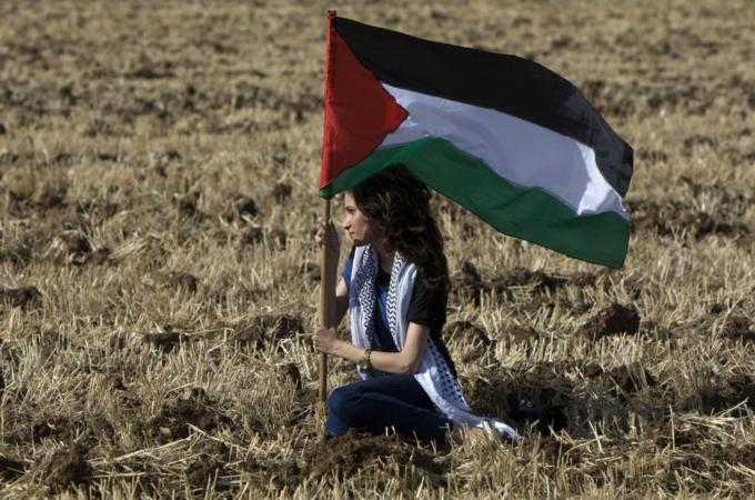 An Arab Israeli protestors holds up Pale
