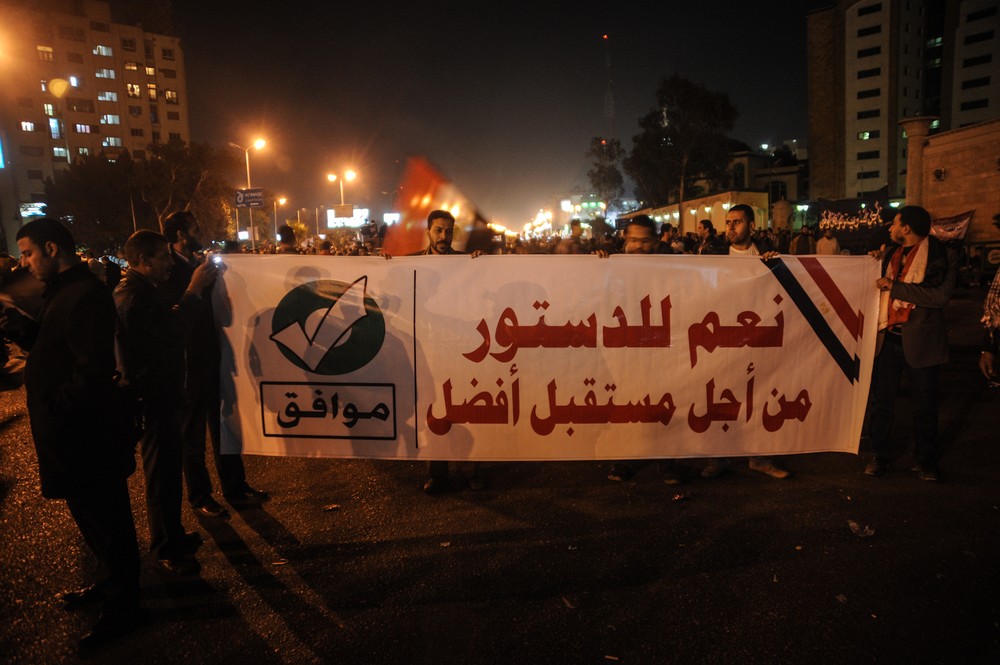 Members of the Muslim Brotherhood march with a banner that reads, "Yes to the constitution, for a better future" in Nasr City, Cairo. Rival sides in Egypt are staging rallies a 
day before the first round of voting begins on a contentious draft 
constitution.