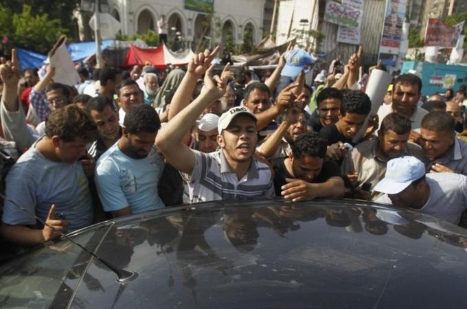 Supporters of Mursi gather around a car carrying the body of a fellow supporter killed by violence in Cairo