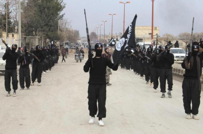 Al-Qaeda linked fighters carry their weapons during a parade at the Syrian town of Tel Abyad [Reuters]