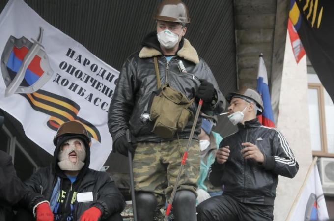 Pro-Russian activists guard a regional administration building that they had seized earlier in Donetsk, Ukraine [AP]