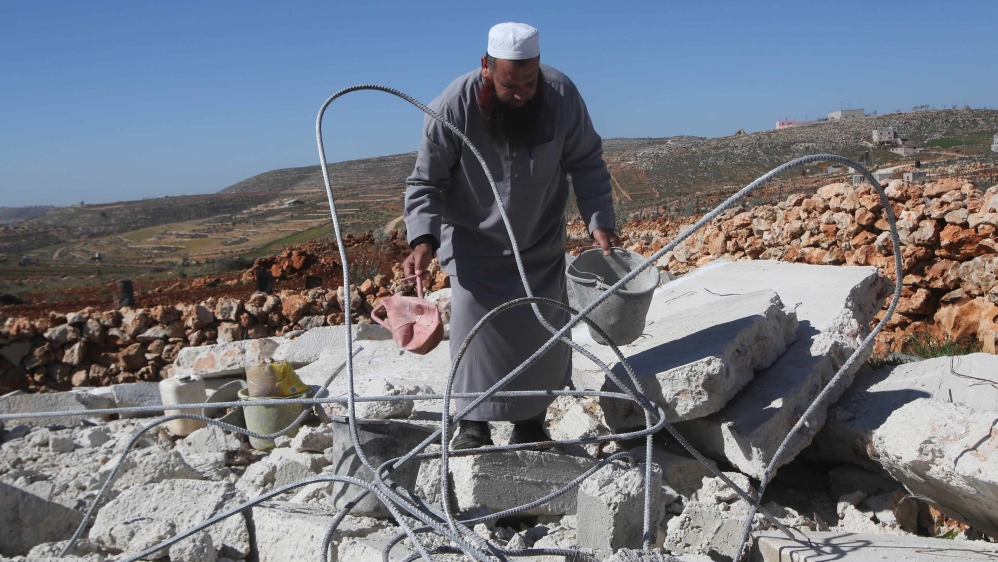 Palestinian villager Ziyad Odeh searches for his belongings amongst the rubble of his house after it was demolished by an Israeli army bulldozer, in the West Bank village of Qosra near Nablus