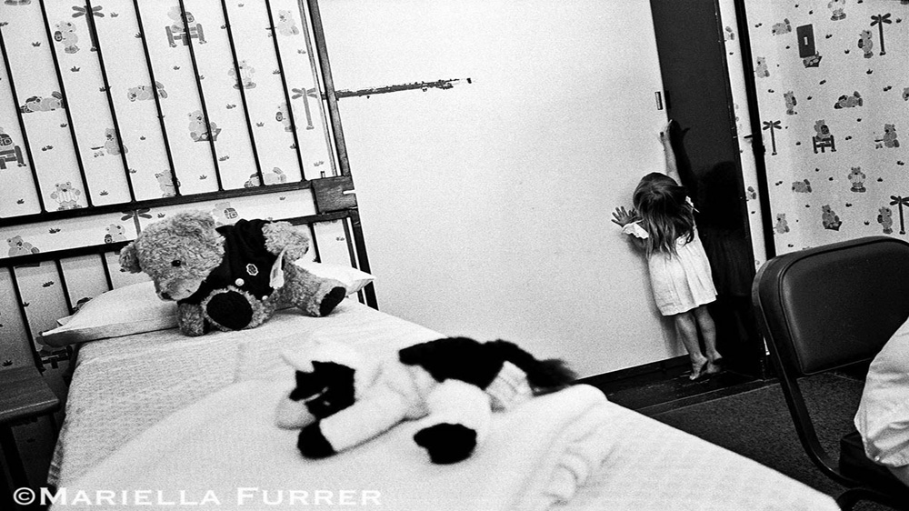A young girl attempts to flee from the examining room before a medical forensic examination. A nine-year-old relative who admitted to playing “sexual games” with her was later discovered to have been abused himself. Both children were sent for counselling. The Teddy Bear Clinic for Abused Children, Johannesburg, March 2003 [Mariella Furrer]