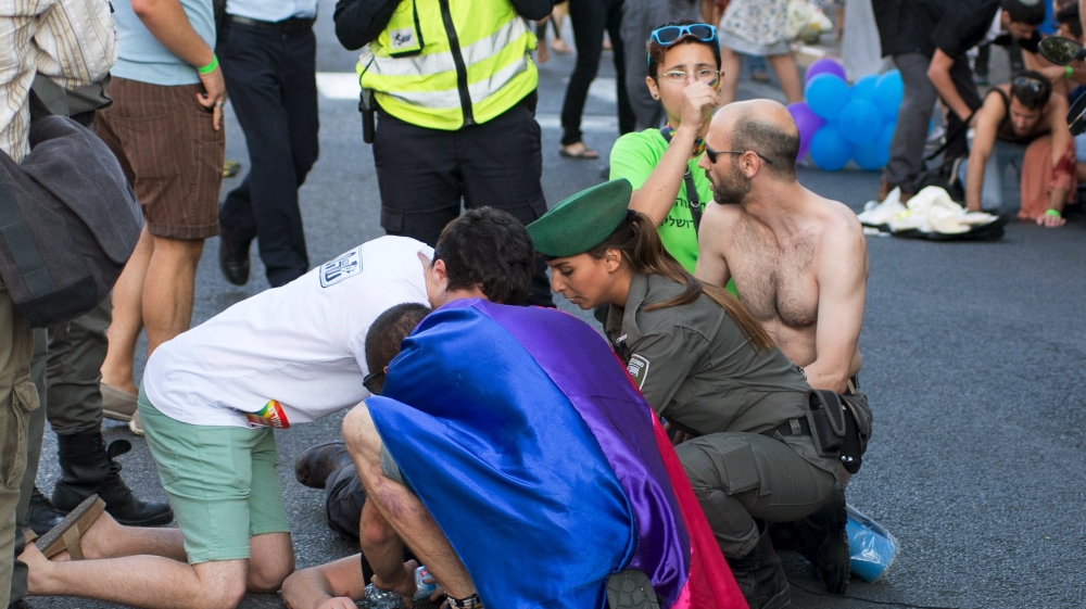 A participant of an annual gay pride parade is treated after an Orthodox Jewish assailant stabbed and injured six participants in Jerusalem on Thursday, police and witnesses said