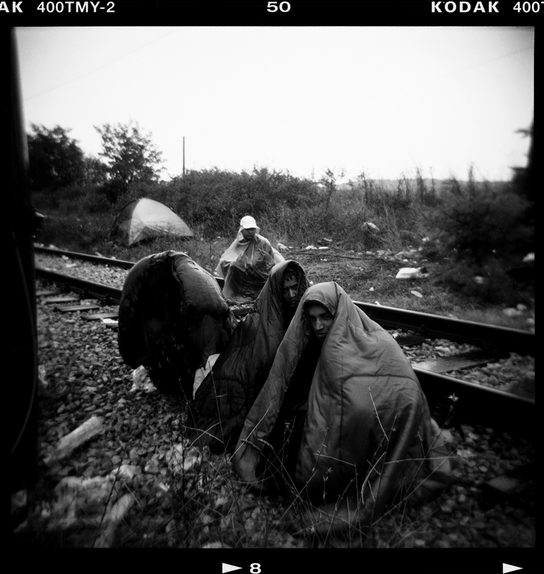 Men from Pakistan wait on the railway tracks at the Greece-Macedonia border, near the village of Idomeni – Idomeni, Greece, August 2015 [Giorgos Moutafis]