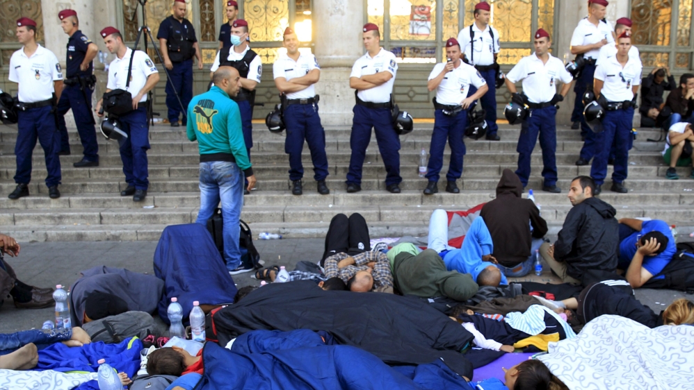 Migrants rest outside the main Eastern Railway station in Budapest