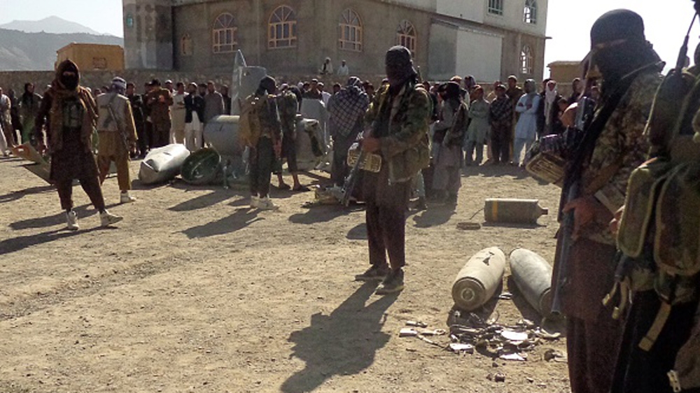 Afghan Taliban militants gather around parts of a US F-16 aircraft that was struck over in Sayid Karam district of eastern Paktia province [AFP]