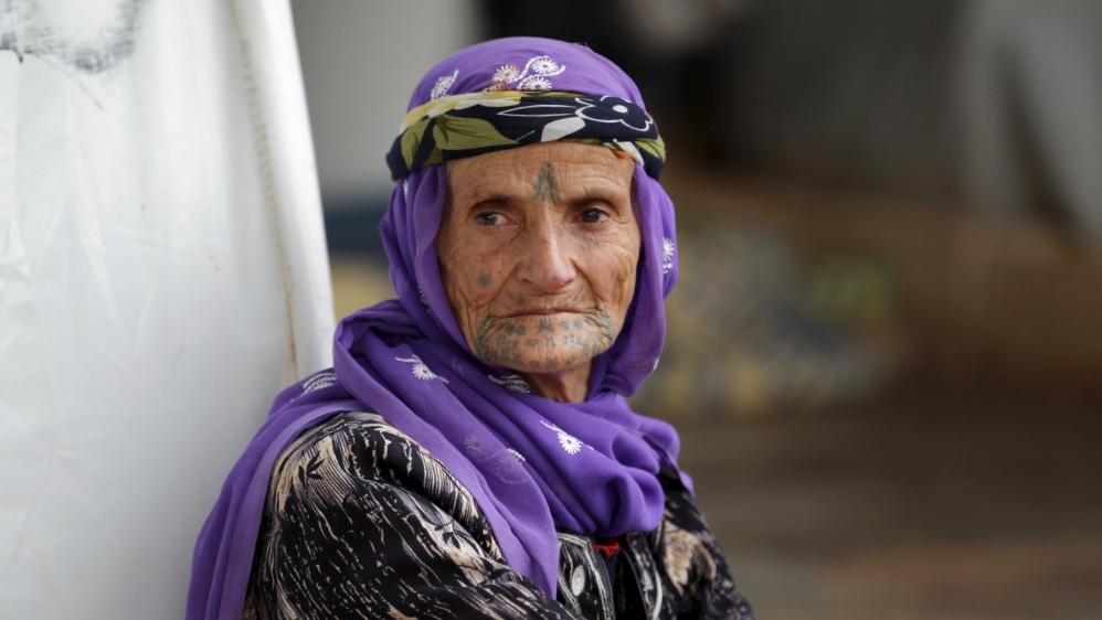 An internally displaced woman sits outside tents inside Atma refugee camp beside the Syrian-Turkish border in northern Idlib countryside
