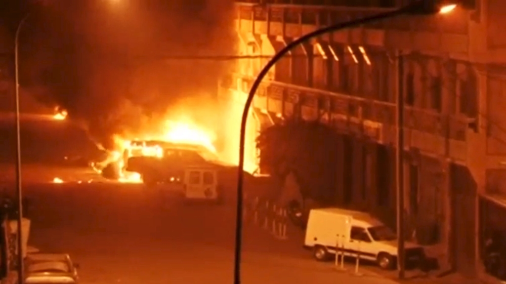 View shows vehicles on fire outside Splendid Hotel in Ouagadougou