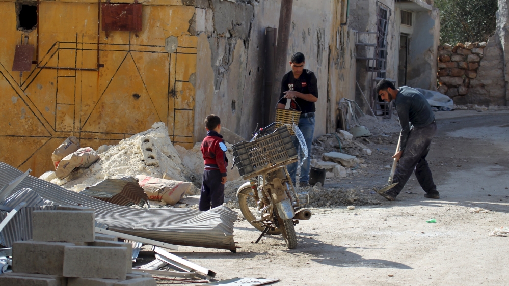 Residents work on fixing a house in the town of Darat Izza, province of Aleppo