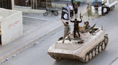 ISIL fighters take part in a military parade along the streets of northern Raqqa province [Reuters]