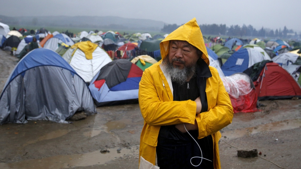 Chinese dissident artist Ai looks on as he visits a migrant''s makeshift camp on the Greek-Macedonian border, near the village of Idomeni