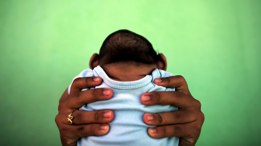 File photo of Jackeline, 26, holding her son Daniel who is 4-months old and born with microcephaly, in front of their house in Olinda