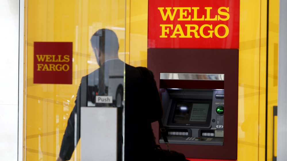 A man walks by an ATM at the Wells Fargo & Co. bank in Denver