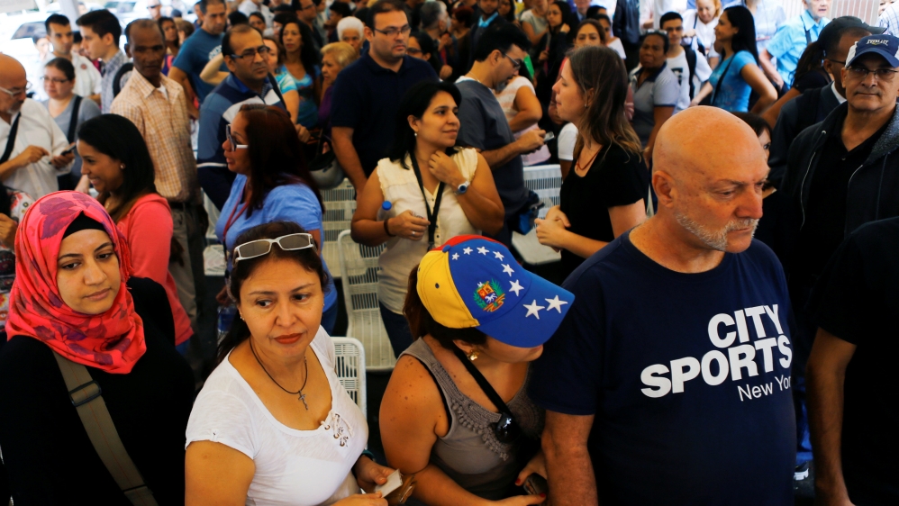 People stand in line as they gather outside a validation center during Venezuela’s CNE second phase of verifying signatures for a recall referendum against President Maduro in Caracas