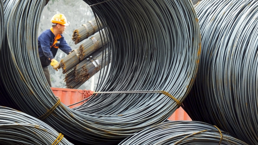 An employee unloads steel products at a market in Yichang