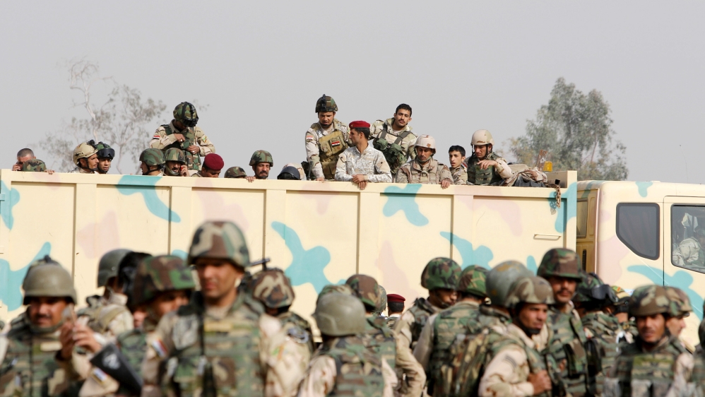 Iraqi security forces ride in trucks travelling to Mosul to fight against militants of Islamic State at an Iraqi army base in Camp Taji in Baghdad