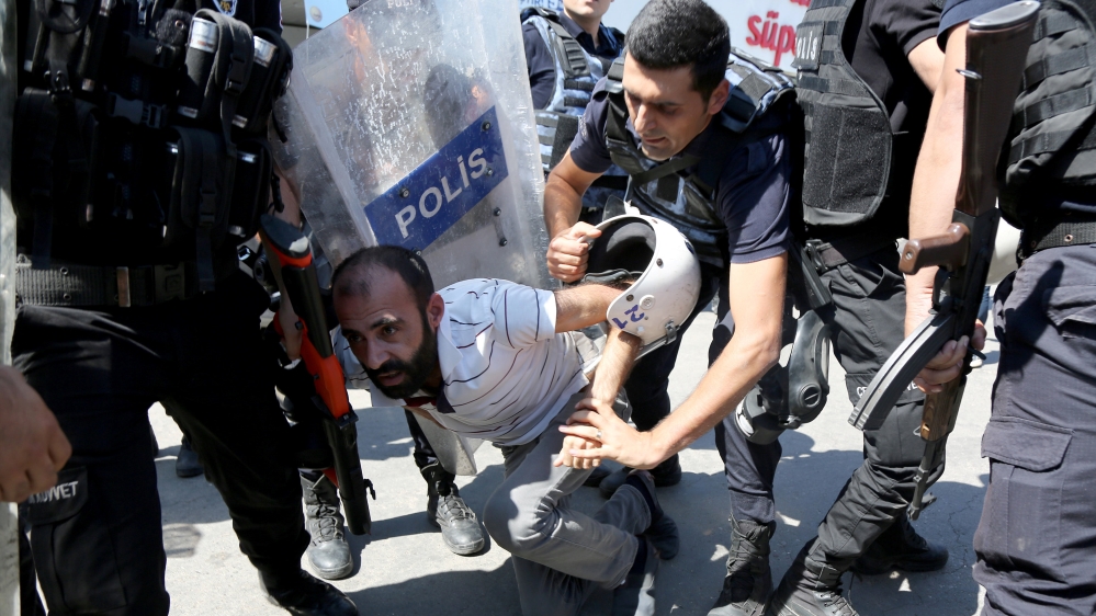 Riot police detain a demonstrator during a protest against suspension of teachers from classrooms over alleged links with the Kurdish militants, in the southeastern city of Diyarbakir