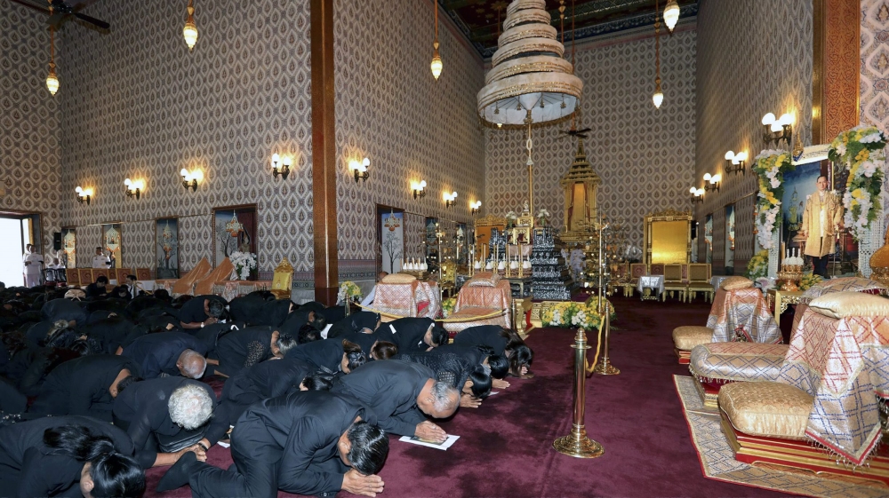 Thai mourners pay their respects in front of a royal urn of the late King Bhumibol Adulyadej