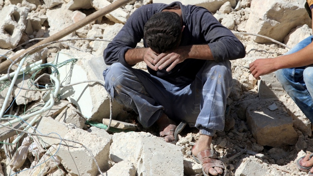 A man reacts on the rubble of damaged buildings after losing relatives to an airstrike in the besieged rebel-held al-Qaterji neighbourhood of Aleppo