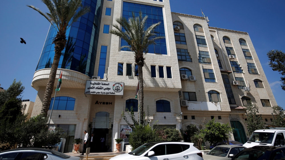 Palestinians walk at the headquarters of the High Court in the West Bank city of Ramallah