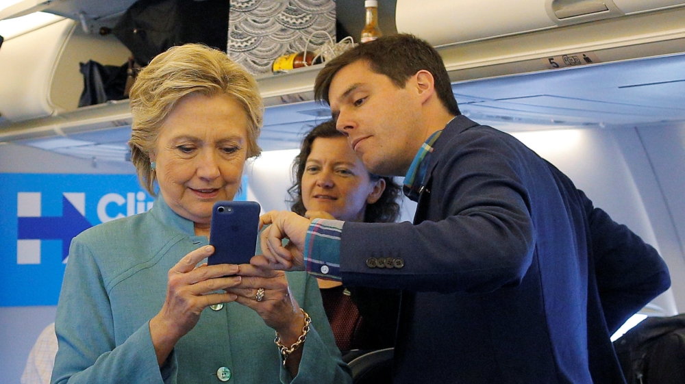 U.S. Democratic presidential nominee Hillary Clinton looks at traveling press secretary Nick Merrill''s mobile phone onboard her campaign plane in Ft. Lauderdale