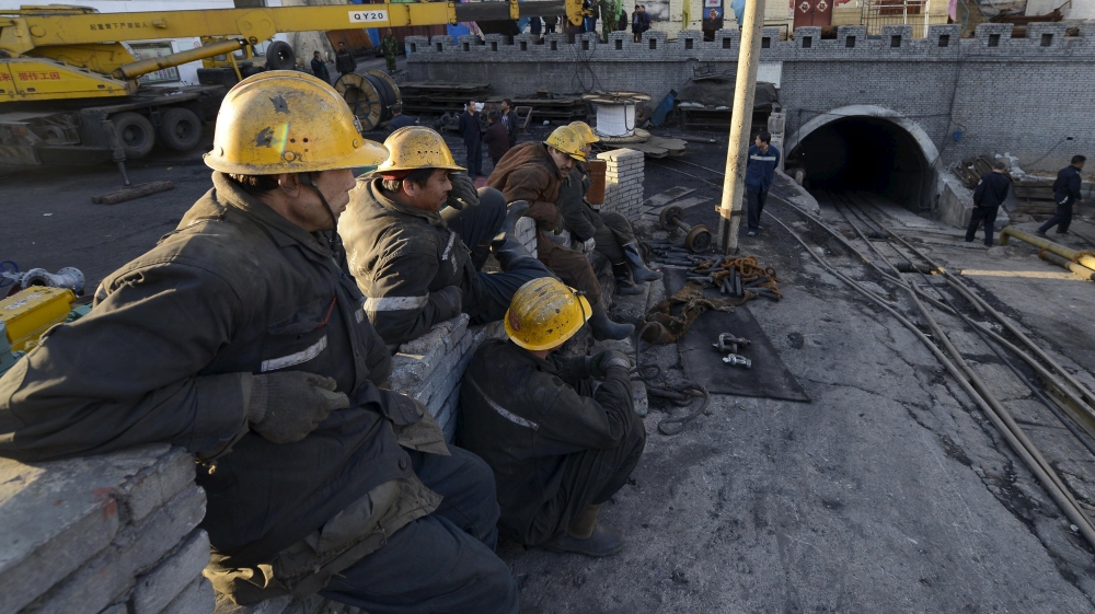 Rescuers sit next to the entrance of a coal mine after a flooding incident in Datong
