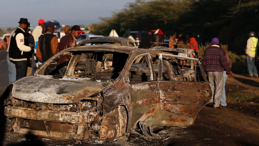 Relatives and civilians look at the wreckages of cars burnt after a fireball from an tanker engulfed several vehicles and killed several people, near the Rift Valley town of Naivasha,