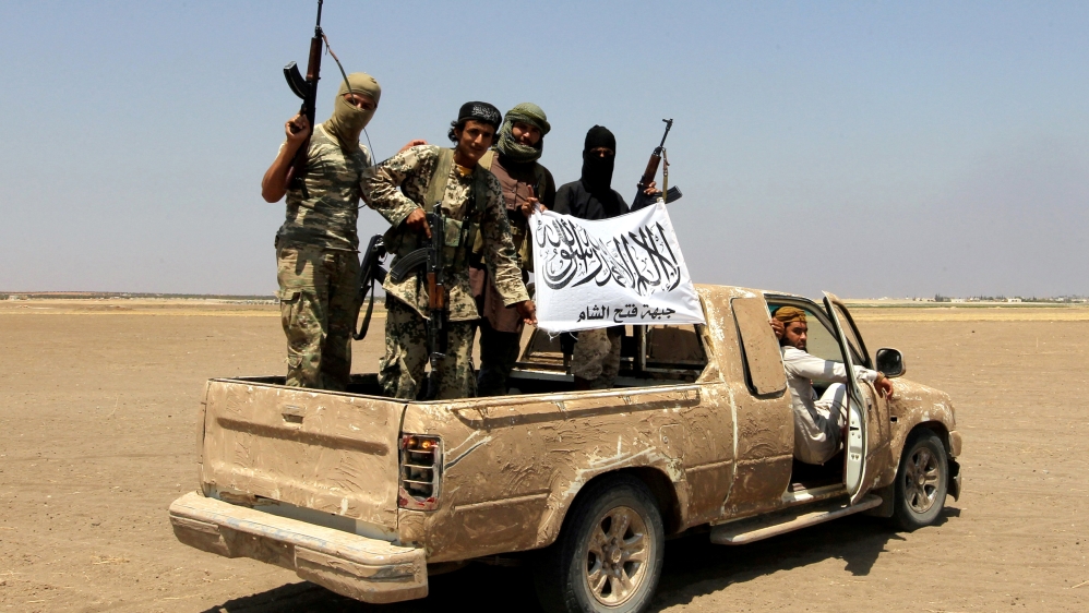 FILE PHOTO: Fighters of the Syrian Islamist rebel group Jabhat Fateh al-Sham cheering after a Russian helicopter was shot down in the north of Syria''s rebel-held Idlib province
