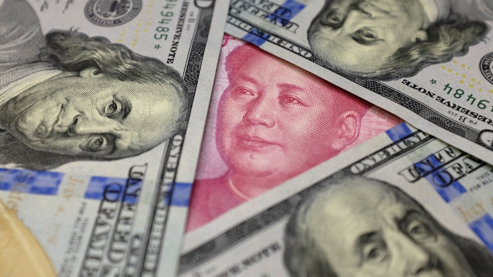 FILE PHOTO - U.S. 100 dollar banknotes and a Chinese 100 yuan banknote are seen in this picture illustration
