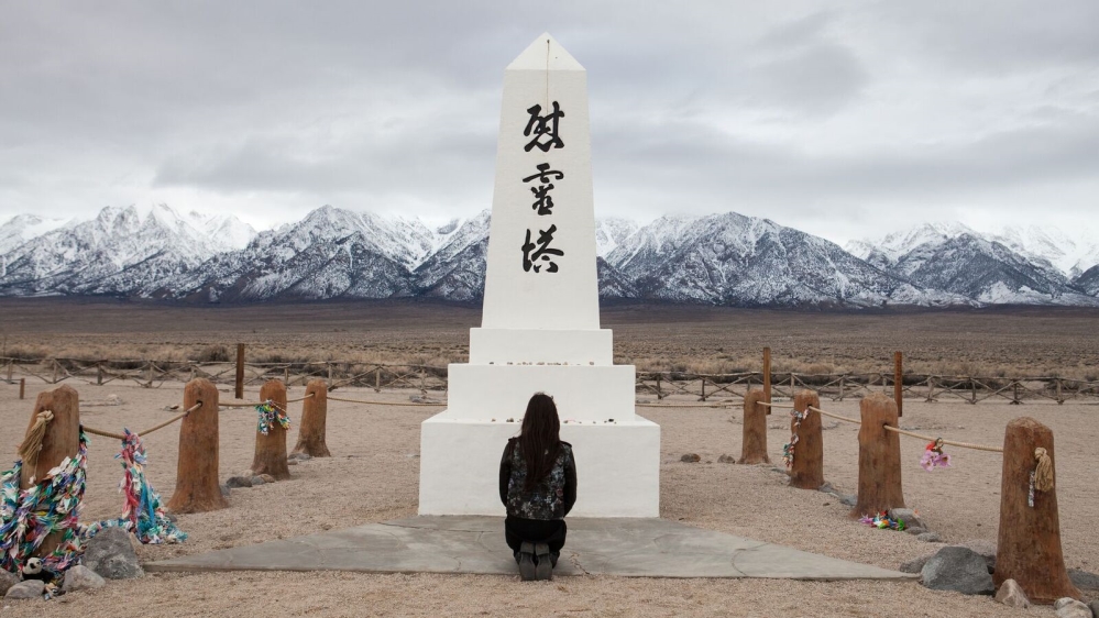 Nakamaru pays her respects at a monument - an obelisk that sits at the back of the former camp [Jessica Chou/Al Jazeera] 