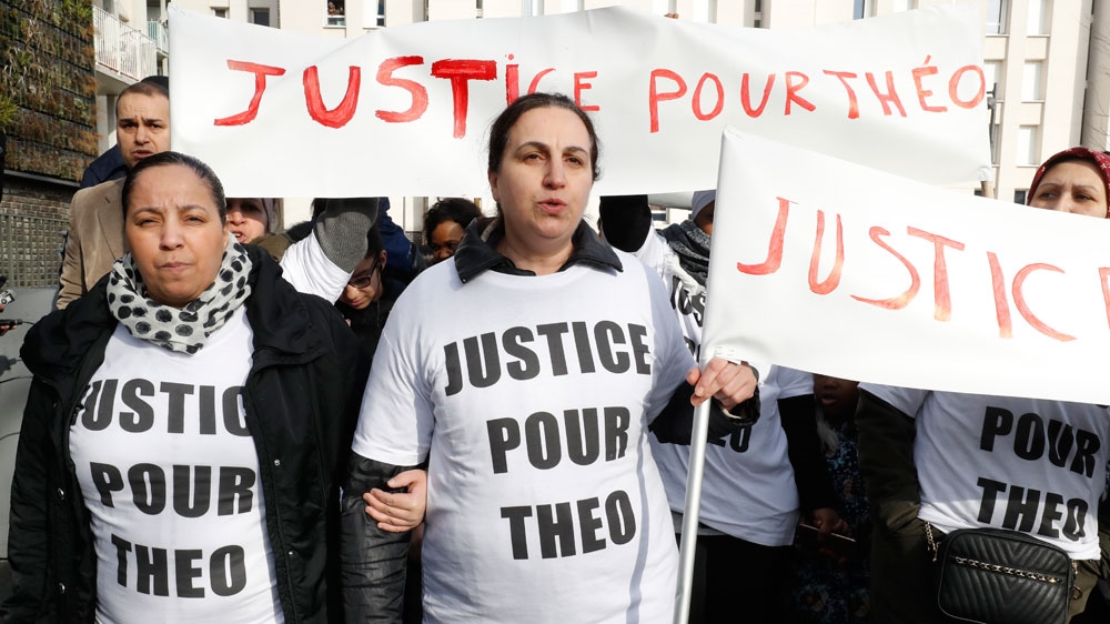 Women hold signs reading 