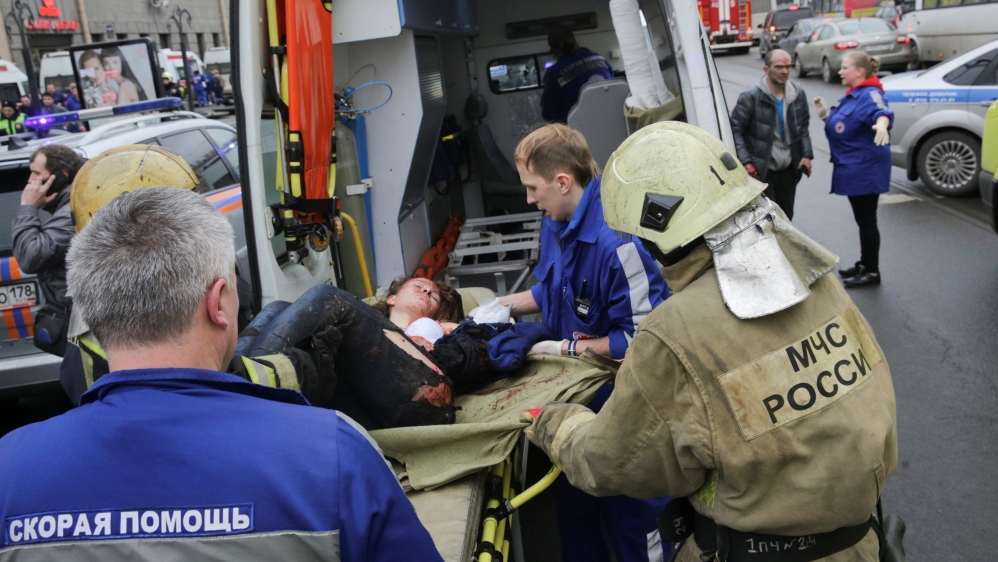 An injured person is helped by emergency services outside Sennaya Ploshchad metro station following explosions in St. Petersburg