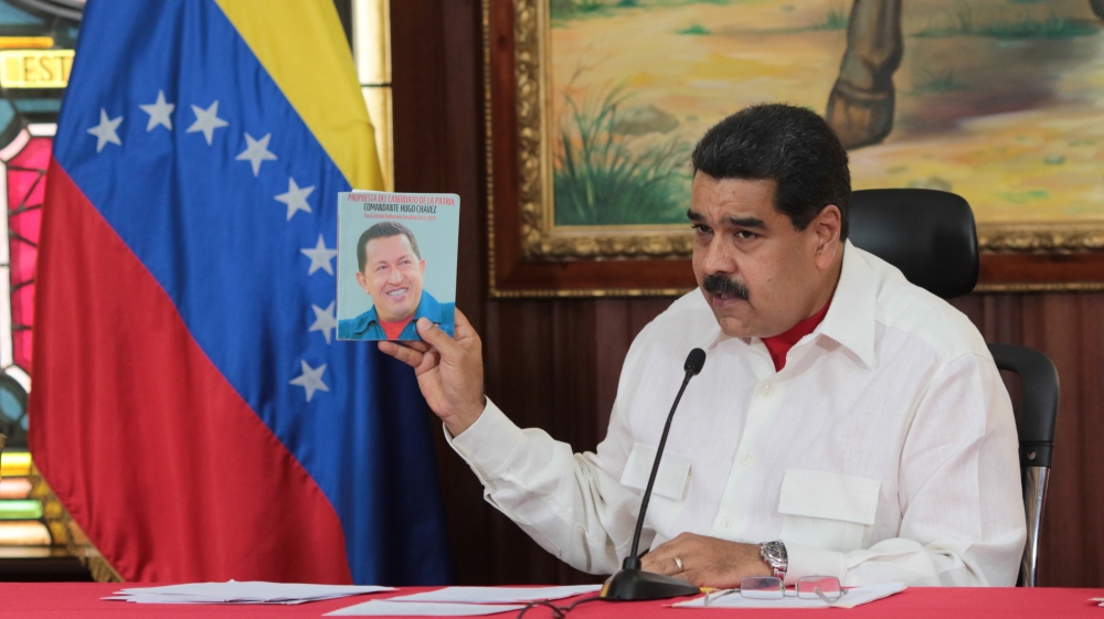 Maduro holds an image of Chavez in Caracas