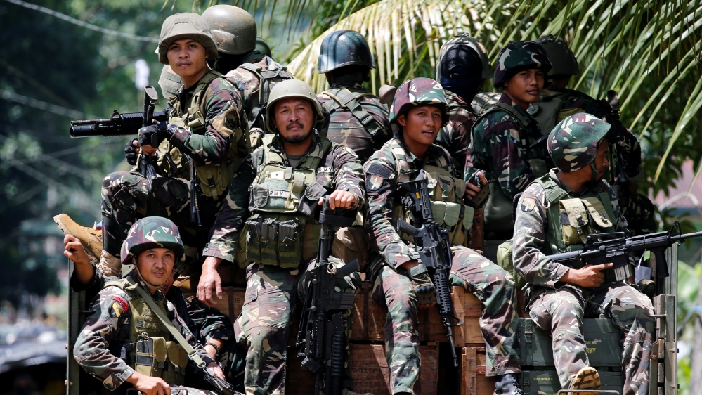 Philippines army soldiers ride in trucks into the fighting zone as government troops continue their assault against insurgents from the Maute group in Marawi City