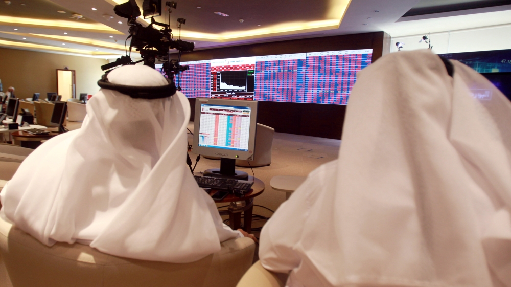 Traders monitor screens displaying stock information at Qatar Stock Exchange in Doha