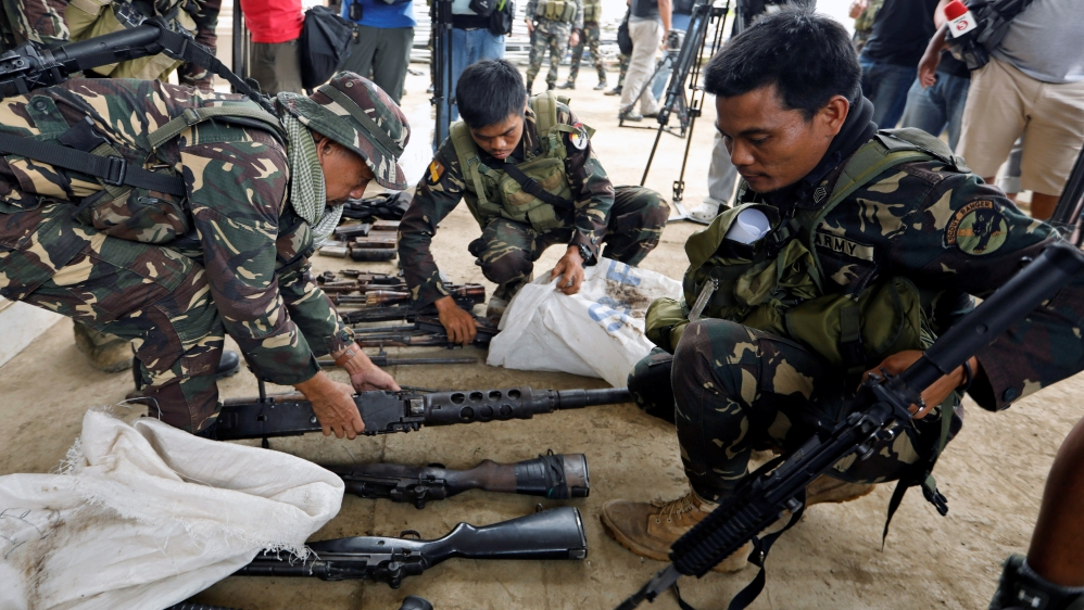 Philippines army soldiers store seized combat weapons in bags after a news conference, as government troops continue their assault against insurgents from the Maute group in Marawi city