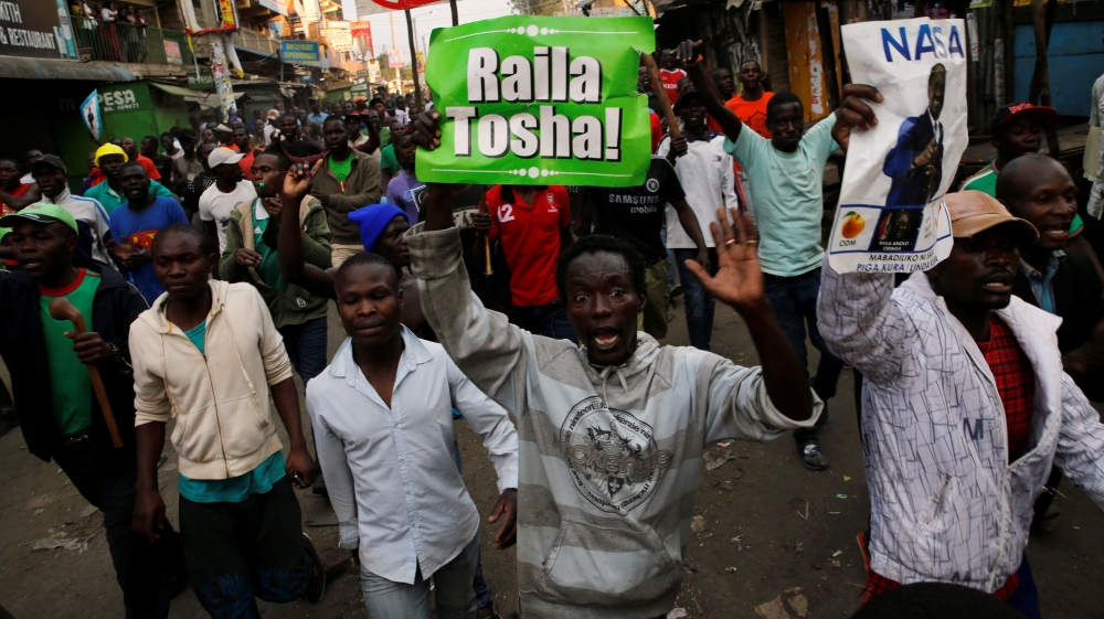 Supporters of Kenyan opposition leader Raila Odinga carry banners as they walk along a street in Humura neighbourhood