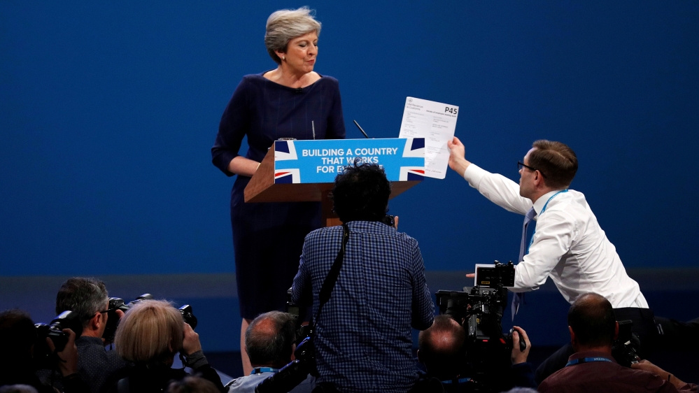A member of the audience hands a P45 form (termination of employment tax form) to Britain''s Prime Minister Theresa May as she addresses the Conservative Party conference in Manchester
