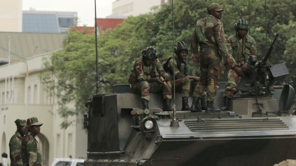 Soldiers are seen next to and on the armoured vehicle on the street in central Harare