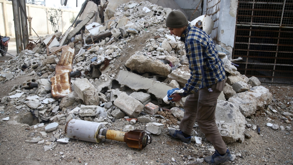 A man is seen near the remains of a rocket in Douma