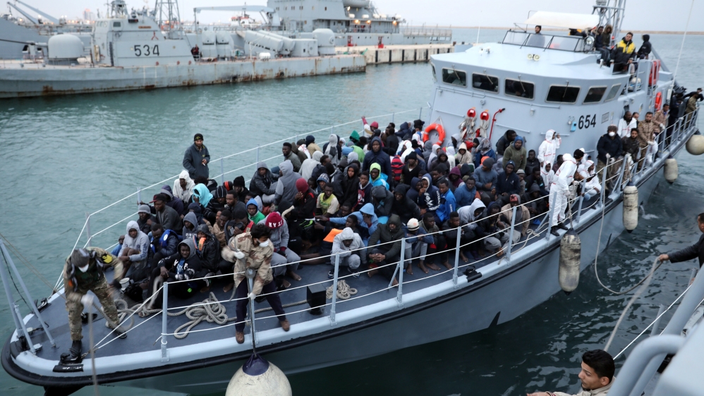 Migrants in a boat arrive at a naval base after they were rescued by Libyan coast guards, in Tripoli