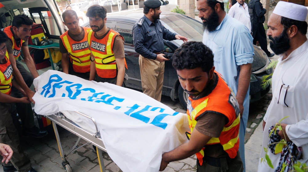 Rescue workers move the body of Ikramullah Gandapur, a candidate of the Pakistan Tehreek-e-Insaf (PTI), or Pakistan Justice Movement, who was killed in a suicide attack in Der