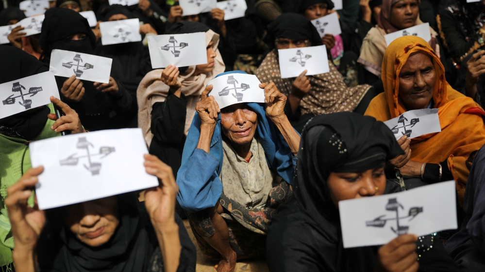 Rohingya refugee women hold placards as they take part in a protest at the Kutupalong refugee camp to mark the one-year anniversary of their exodus in Cox''s Bazar