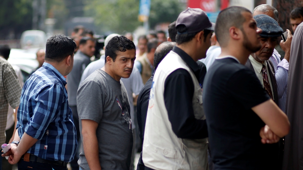 Public servants of the Palestinian Authority queue to receive their salaries outside a bank in Gaza City