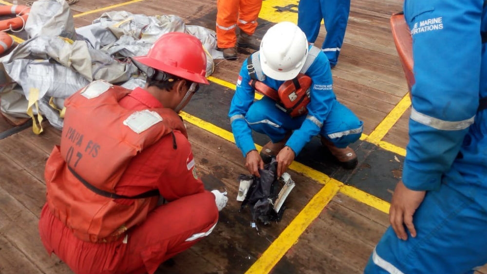 Oil workers inspect debris [Courtesy: National Disaster Mitigation Agency]
